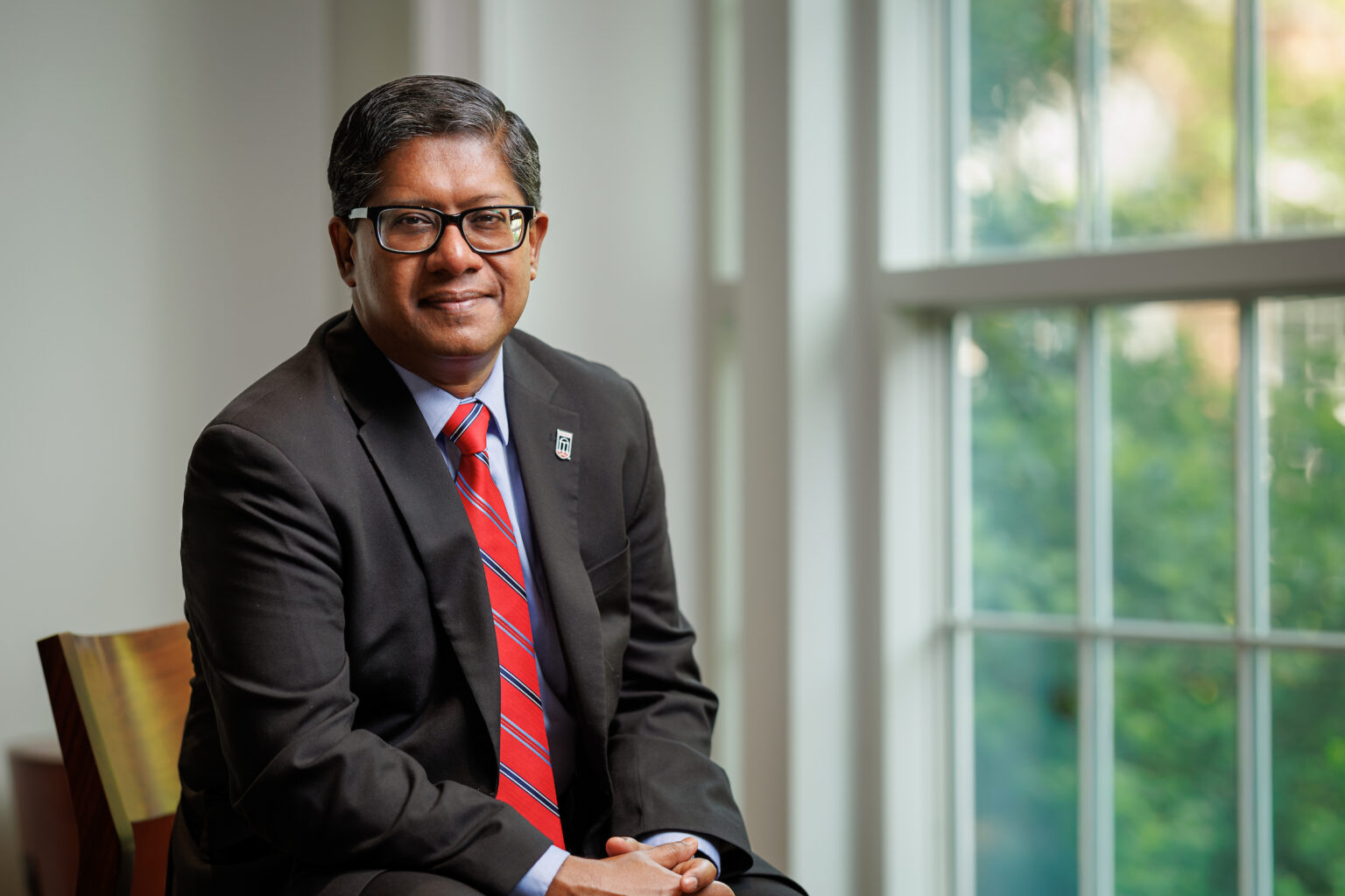 Dean Santanu Chatterjee sits by a window in the Terry College Business Learning Community